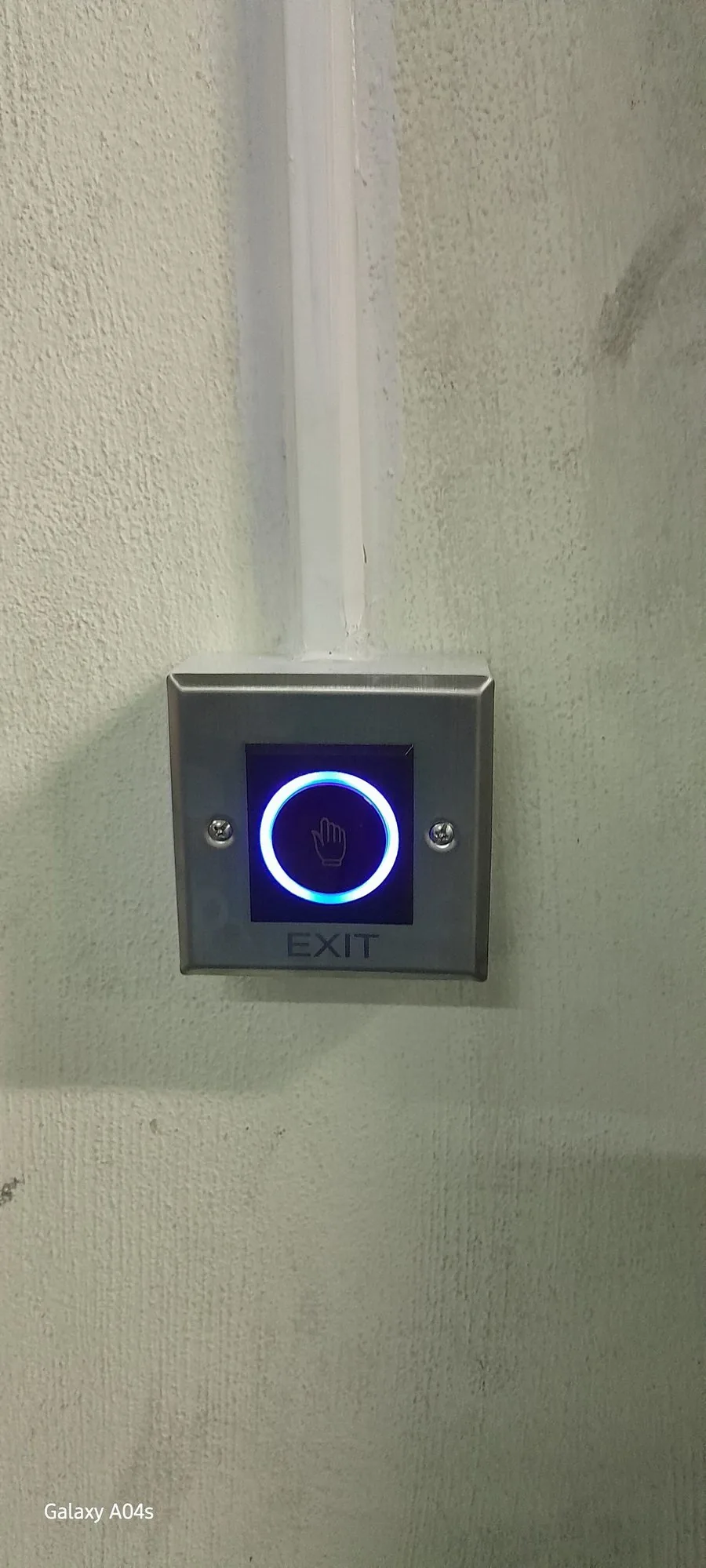 สวิตช์ไร้สัมผัส No-touch Switch รุ่น ATD-SW03 ติดตั้งที่ผนังฝั่งทางออก มีไฟ LED วงแหวนสีฟ้าและสัญลักษณ์มือ พร้อมป้าย EXIT